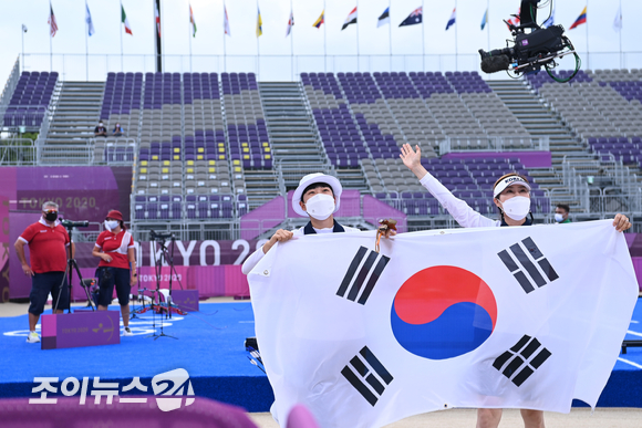 한국 양궁 안산이 30일 일본 도쿄 유메노시마공원 양궁장에서 열린 2020 도쿄올림픽 양궁 여자 개인전 결승에서 ROC(러시아올림픽위원회)의 옐레나 오시포바를 누르고 금메달을 차지했다. 안산이 류수정 감독과 태극기 세리머니를 하고 있다.