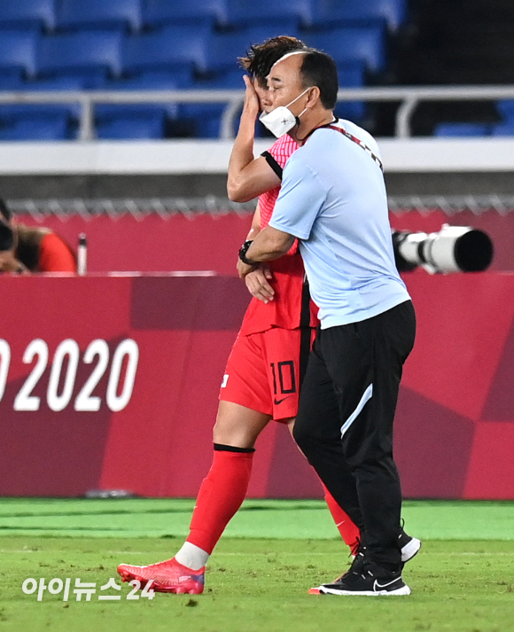 한국 김학범 감독이 31일 오후 일본 요코하마 국제 종합경기장에서 진행된 '2020 도쿄올림픽' 남자축구 8강전 대한민국과 멕시코의 경기에서 3-6으로 패배한 후 눈물을 흘리는 이동경을 다독이고 있다.