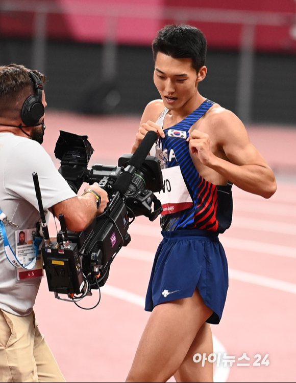 한국 육상 우상혁이 1일 오후 일본 도쿄 올림픽스타디움에서 열린 2020 도쿄올림픽 육상 남자 높이뛰기 결선에 출전해 중계카메라에 태극 마크를 가리키고 있다.