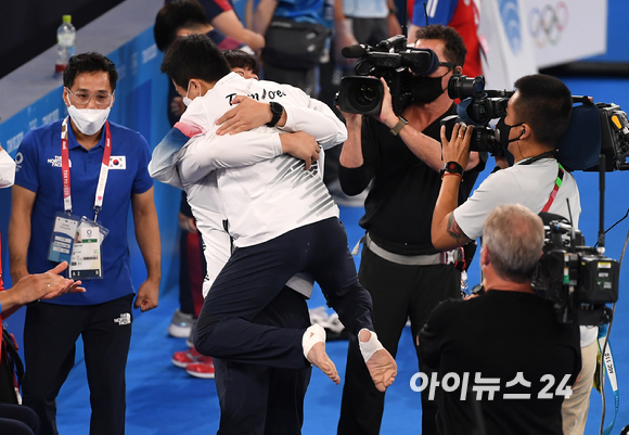 2일 일본 도쿄 아리아케 체조경기장에서 '2020 도쿄올림픽' 남자 기계체조 도마 결선 경기가 열렸다. 대한민국 신재환이 금메달이 확정되자 감독과 포옹하고 있다. 