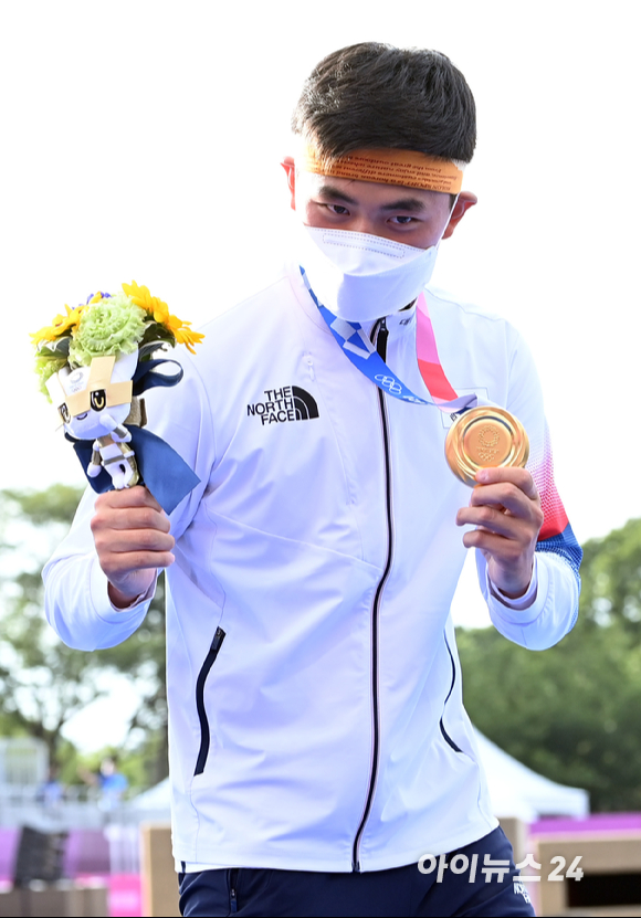 양궁 국가대표 김제덕이 26일 오후 일본 도쿄 유메노시마 공원 양궁장에서 열린 2020 도쿄올림픽 남자양궁 단체전 대만과의 결승전에서 금메달을 따낸 후 기념 촬영을 하고 있다.