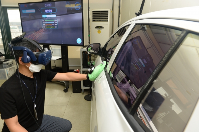 ETRI 연구진이 스팀세차 가상 직업훈련을 위한 VR 기술 시연을 하고 있는 모습 [사진=ETRI]
