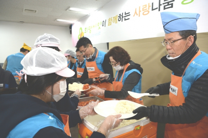 은성수 수출입은행장(사진 맨오른쪽)이 29일 임직원들과 함께 서울역 인근 무료급식소 '따스한 채움터'을 찾아 노숙인들을 대상으로 배식 봉사를 하고 있다.