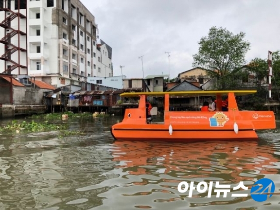 한화그룹이 베트남 남부 빈롱시에 기증한 쓰레기 수거용 태양광 보트가 메콩강을 청소하고 있다. [사진=한화]