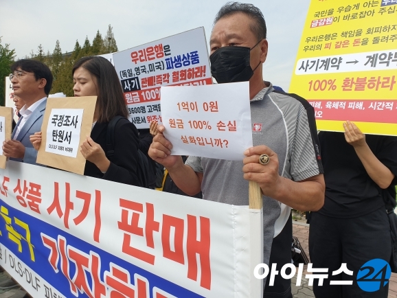 27일 서울 여의도 국회 앞에서 진행된 DLS피해자 기자회견에서 한 피해자가 피켓을 들고 있다. [사진=서상혁 기자]