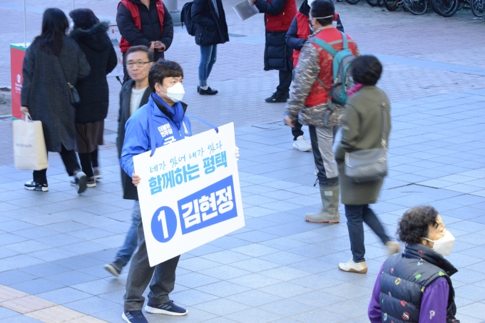 평택을에 출마하는 김현정 더불어민주당 예비후보가 24일 피켓을 걸고 시민들에게 인사하고 있다.  [김현정선거사무소 제공]