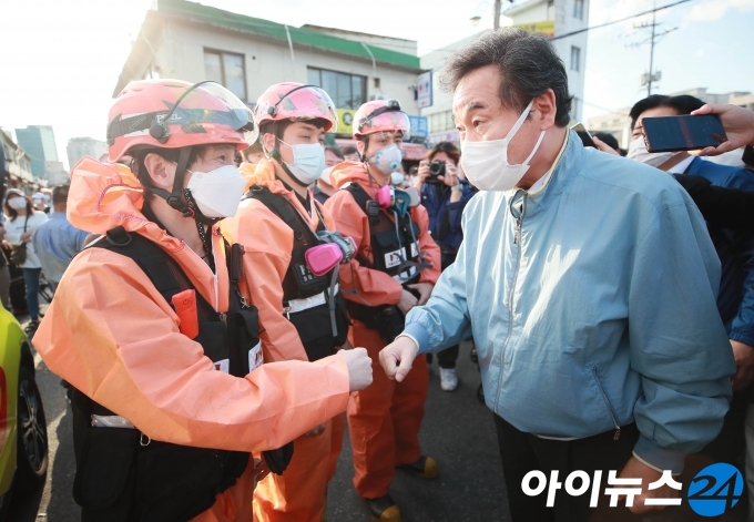 이낙연 더불어민주당 대표가 22일 오후 서울 동대문구 청량리 청과물시장 화재현장을 찾아 소방대원들과 인사하고 있다. 