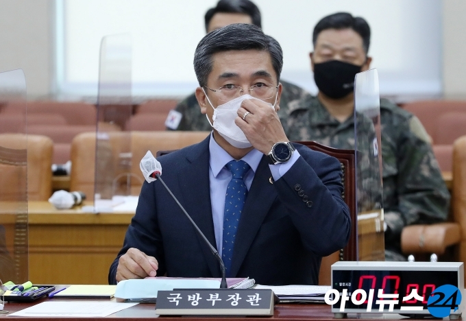 서욱 국방부 장관이 24일 오후 서울 여의도 국회에서 열린 국방위원회 전체회의에 참석해 회의 시작 전 마스크를 고쳐쓰고 있다.
