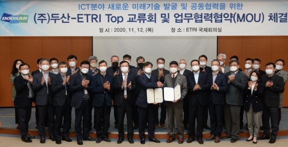 한국전자통신연구원(ETRI) 대전본원에서 열린 ㈜두산과 ETRI의 'ICT 분야 미래기술 발굴 및 협력' 협약식에서 동현수 ㈜두산 부회장과 김명준 ETRI 원장을 비롯한 두 기관의 임직원들이 협약식을 마치고 기념촬영을 하고 있다.  [두산]