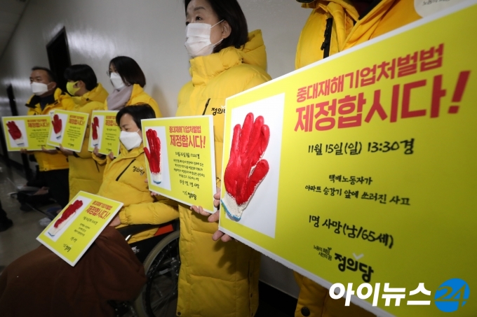 강은미 정의당 원내대표와 의원들이 5일 서울 여의도 국회 법사위원회 전체회의실 앞에서 손팻말을 들고 중대재해기업처벌법 제정을 촉구하고 있다.