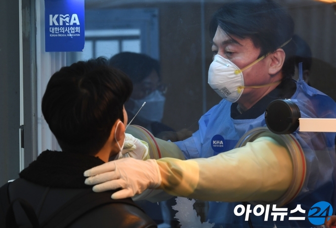 안철수 국민의당 대표가 15일 오전 서울광장에 마련된 임시 선별검사소에서 검체를 채취하는 의료자원봉사를 하고 있다. [국회사진취재단]
