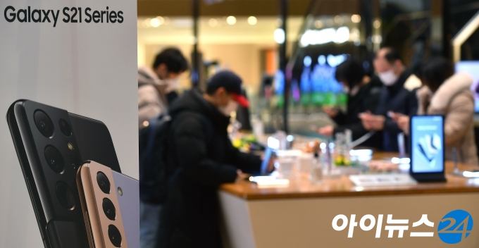 삼성전자가 15일(한국시간) 자정 온라인에서 진행된 '삼성 갤럭시 언팩 2021'을 통해 공개한 플래그십 스마트폰 갤럭시 S21 시리즈를 공개했다. 이날 서울 서초구 삼성전자 서초사옥 딜라이트샵을 찾은 시민들이 새로운 갤럭시 S21을 살펴보고 있다.