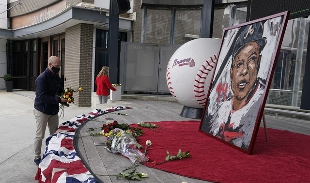 MLB 전설의 홈런왕 행크 애런의 별세 소식이 전해진 뒤 한 야구팬이 그를 추모하기 위해 꽃다발을 놓고 있다.  [사진=뉴시스]