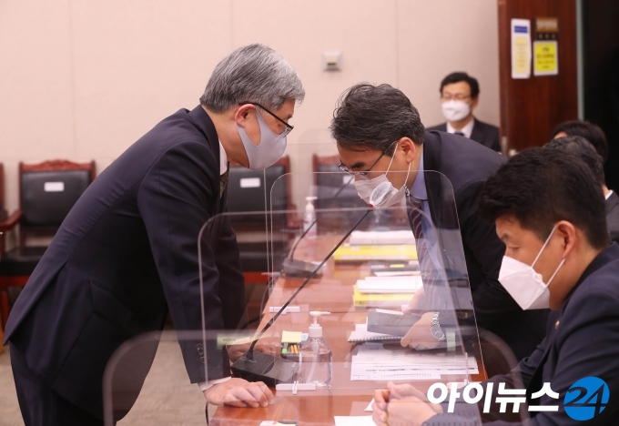 최재형(왼쪽) 감사원장이 22일 오전 서울 여의도 국회에서 열린 법제사법위원회 전체회의에 출석해 관계자와 대화하고 있다.