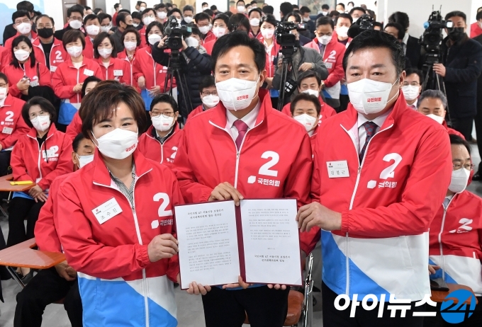 국민의힘 오세훈 서울시장 후보가 11일 서울 여의도 중앙당사에서 열린 4.7 보궐선거 서울선거대책위원회 발대식에서 필승 결의문을 들고 기념촬영을 하고 있다. 왼쪽부터 조수진 홍보본부장, 오 후보, 김철근 대변인. 