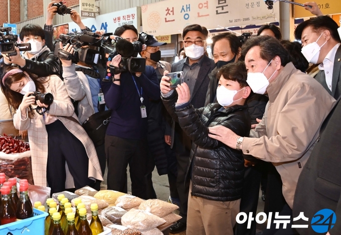 이낙연 더불어민주당 상임선대위원장이 11일 신종 코로나바이러스 감염증(코로나19) 여파로 어려움을 겪는 서울 광장시장을 방문해 한 초등학생과 기념촬영을 하고 있다. [국회사진취재단]