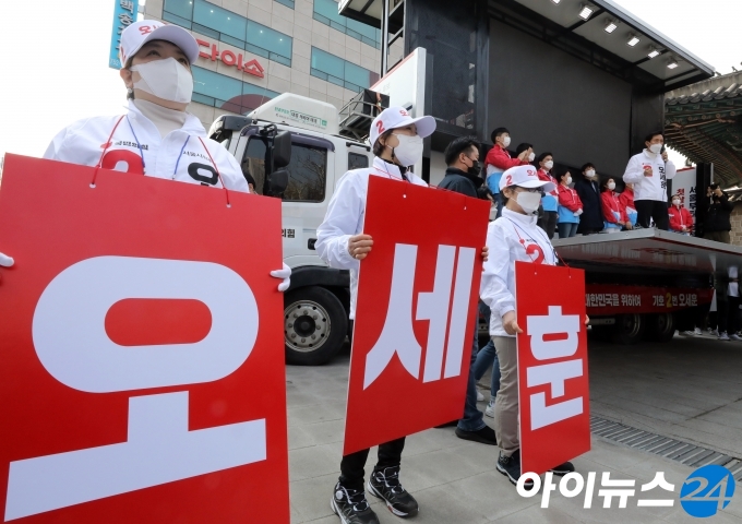 오세훈 국민의힘 서울시장 보궐선거 후보가 25일 오후 서울 덕수궁 대한문 앞에 마련된 유세차에 올라 지지를 호소하는 동안 선거운동원들이 피켓을 들고 있다. [국회사진취재단]