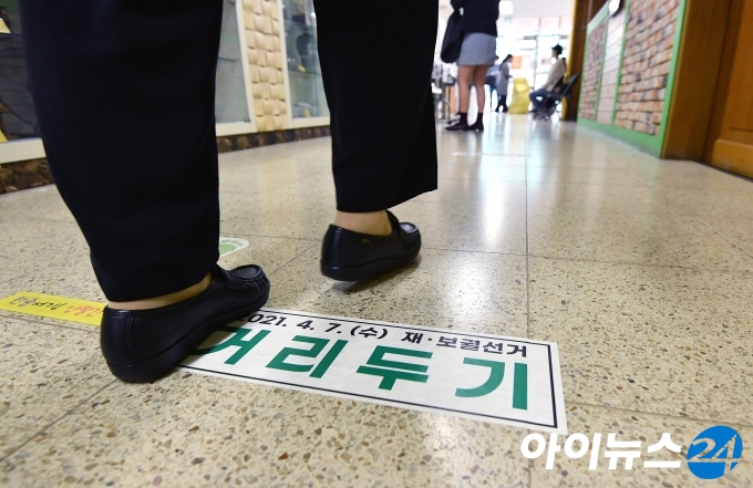 4.7 재보궐선거 투표일인 7일 오전 서울 강서구 양천초등학교에 마련된 가양1동 제1투표소에서 유권자들이 투표를 하기 위해 거리두기를 하며 줄을 서고 있다.