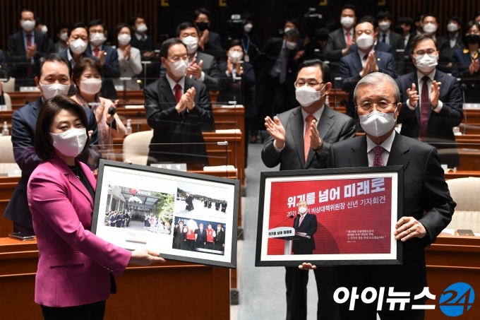 국민의힘 비대위원장 임기가 끝난 김종인 위원장이 8일 오전 서울 여의도 국회에서 열린 의원총회에서 당 홍보국으로부터 기념액자를 받고 있다.