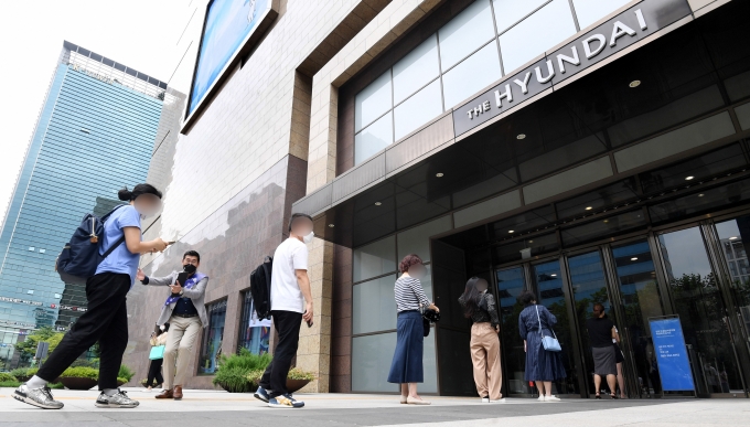 현대백화점 무역센터점의 영업이 재개된 지난 13일 오전 서울 강남구 현대백화점 무역센터점에서 고객들이 QR코드 체크와 체온측정을 위해 줄 서 있다.  [사진=뉴시스]